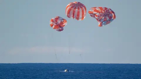 Getty Images Handout photo provided by NASA shows NASA's Orion spacecraft with Artemis II crewmembers NASA astronauts Reid Wiseman, commander; Victor Glover, pilot; Christina Koch, mission specialist; and CSA (Canadian Space Agency) astronaut Jeremy Hansen, mission specialist aboard, as it lands in the Pacific Ocean off the coast of California, Friday, April 10, 2026